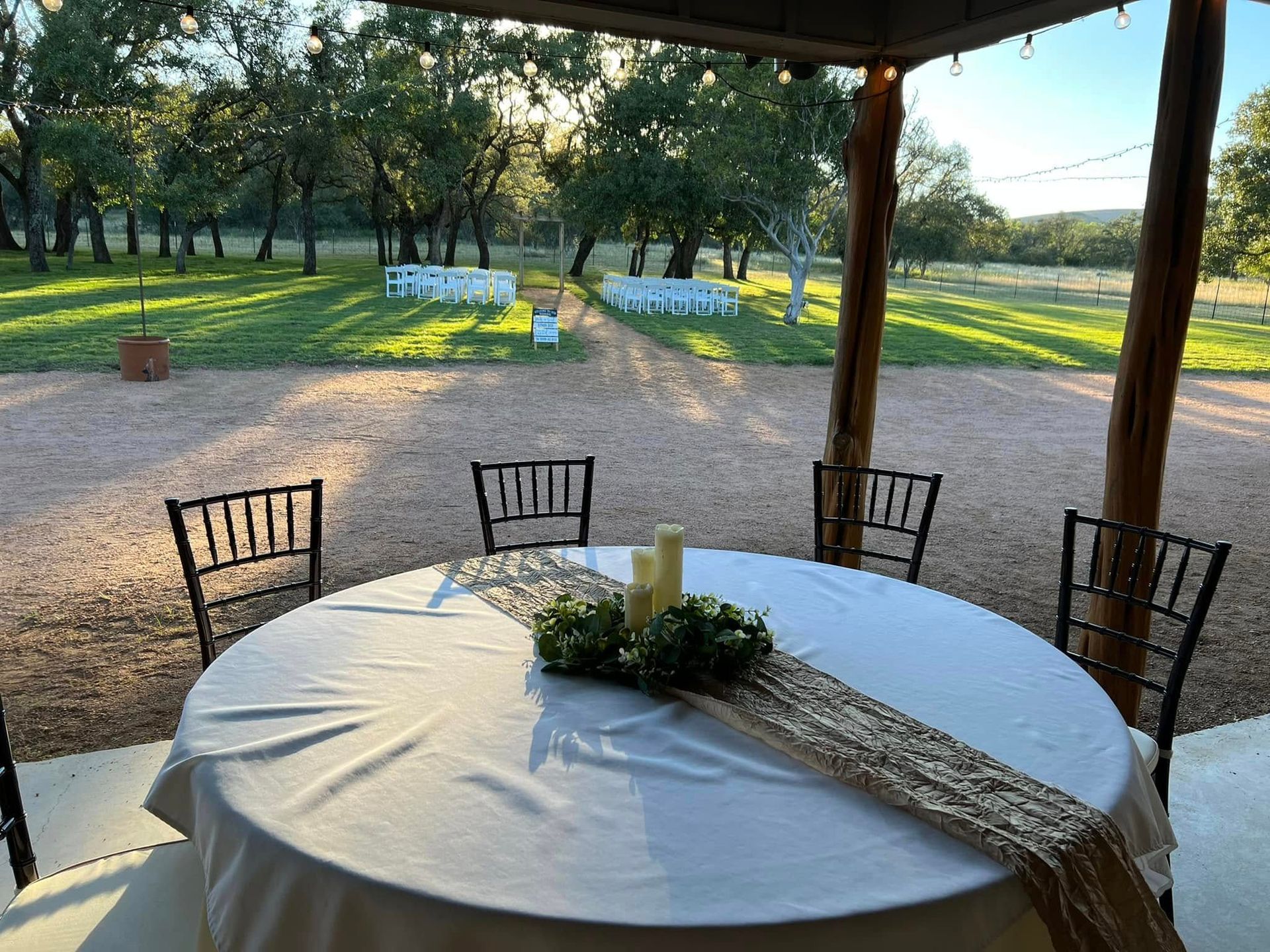 White table with burlap runner, greenery, candles, and a small tealight centerpiece in a dining room