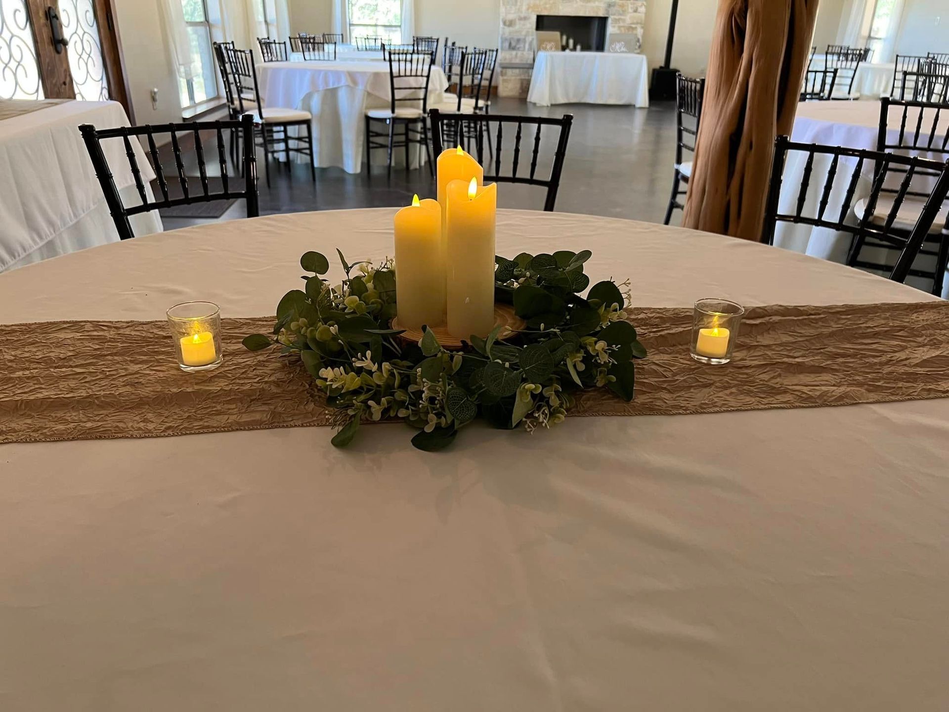 Round banquet table with peach runner, glass vase centerpiece, and teal greenery.