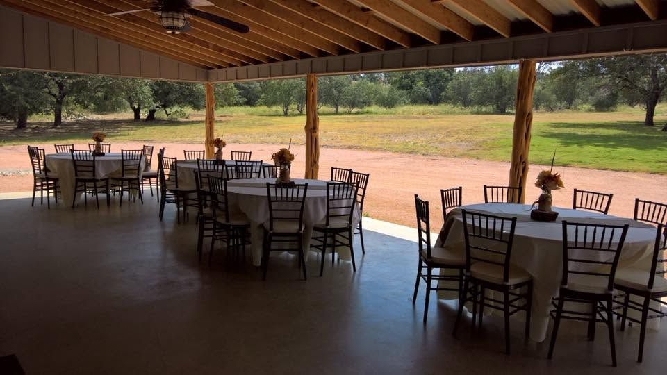 Open-air dining room with tables and chairs overlooking a green sports field