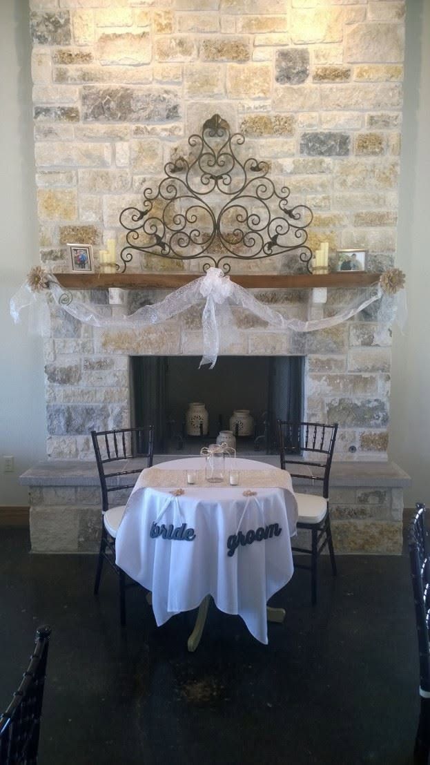 Stone fireplace mantel with ornate black metal decor and white ribbon garland