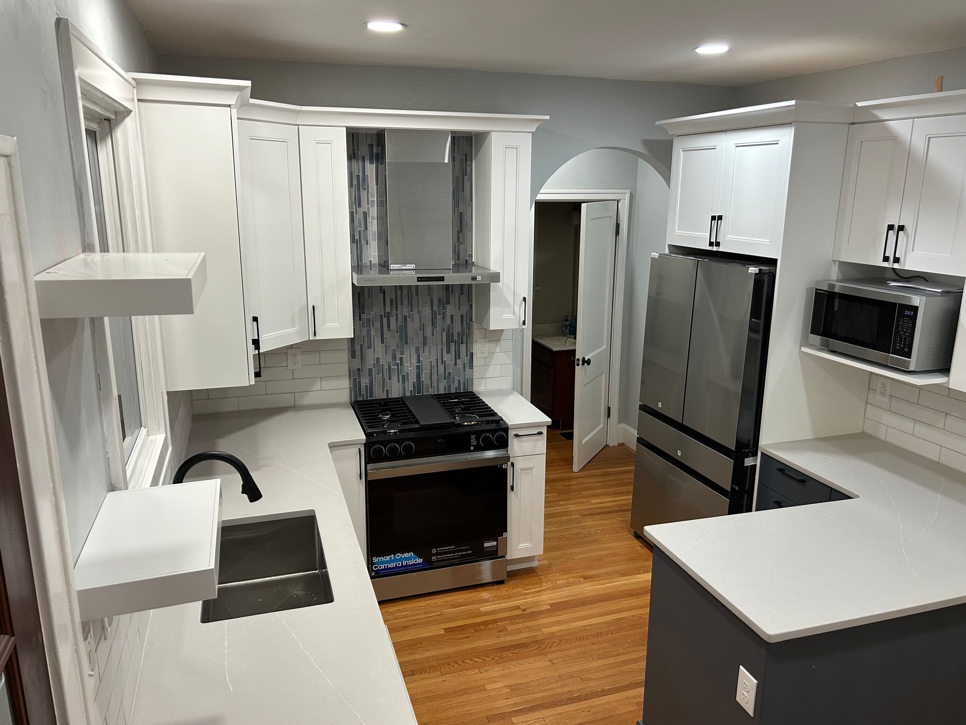 A kitchen with stainless steel appliances and white cabinets.