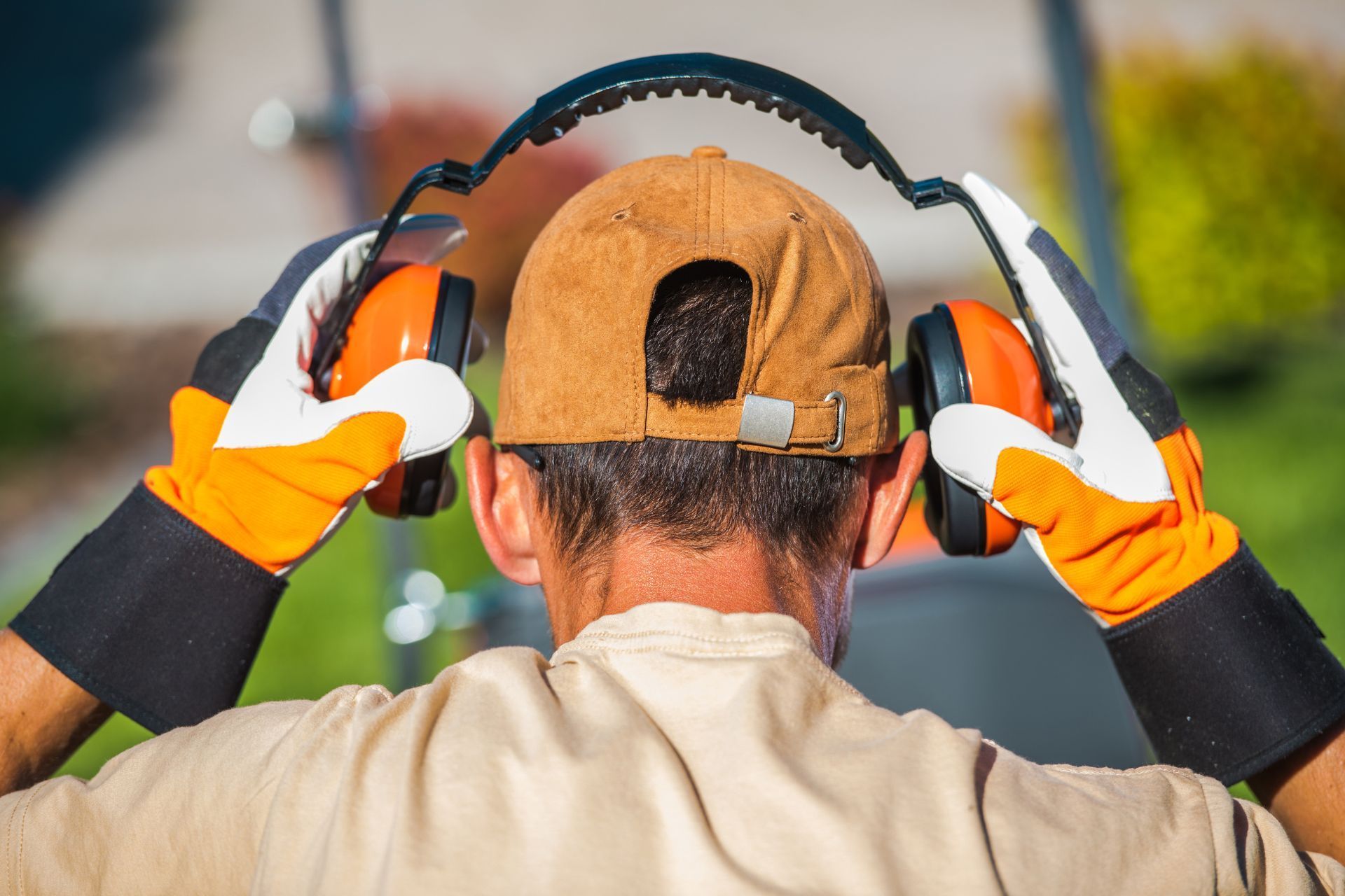 Worker in Athens, GA gearing up with ear protectors and gloves.