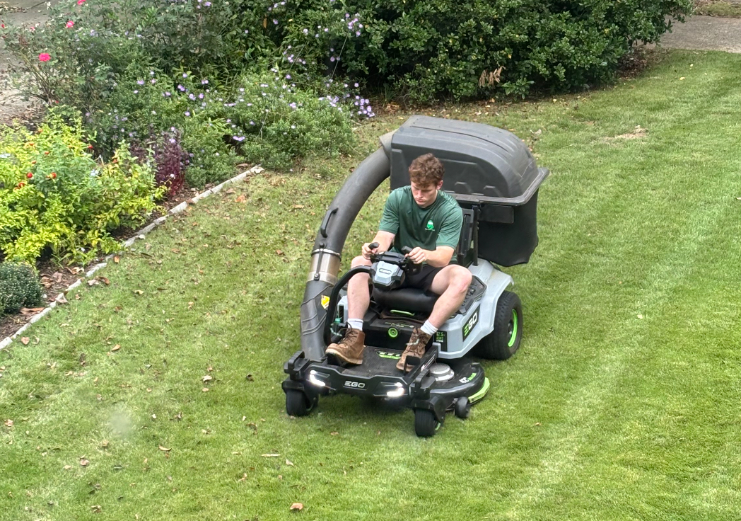 Eco-friendly electric lawn mower in action by Dead Silent Lawn Care on a lush green lawn in Athens, GA, promoting noise-free and sustainable lawn maintenance.