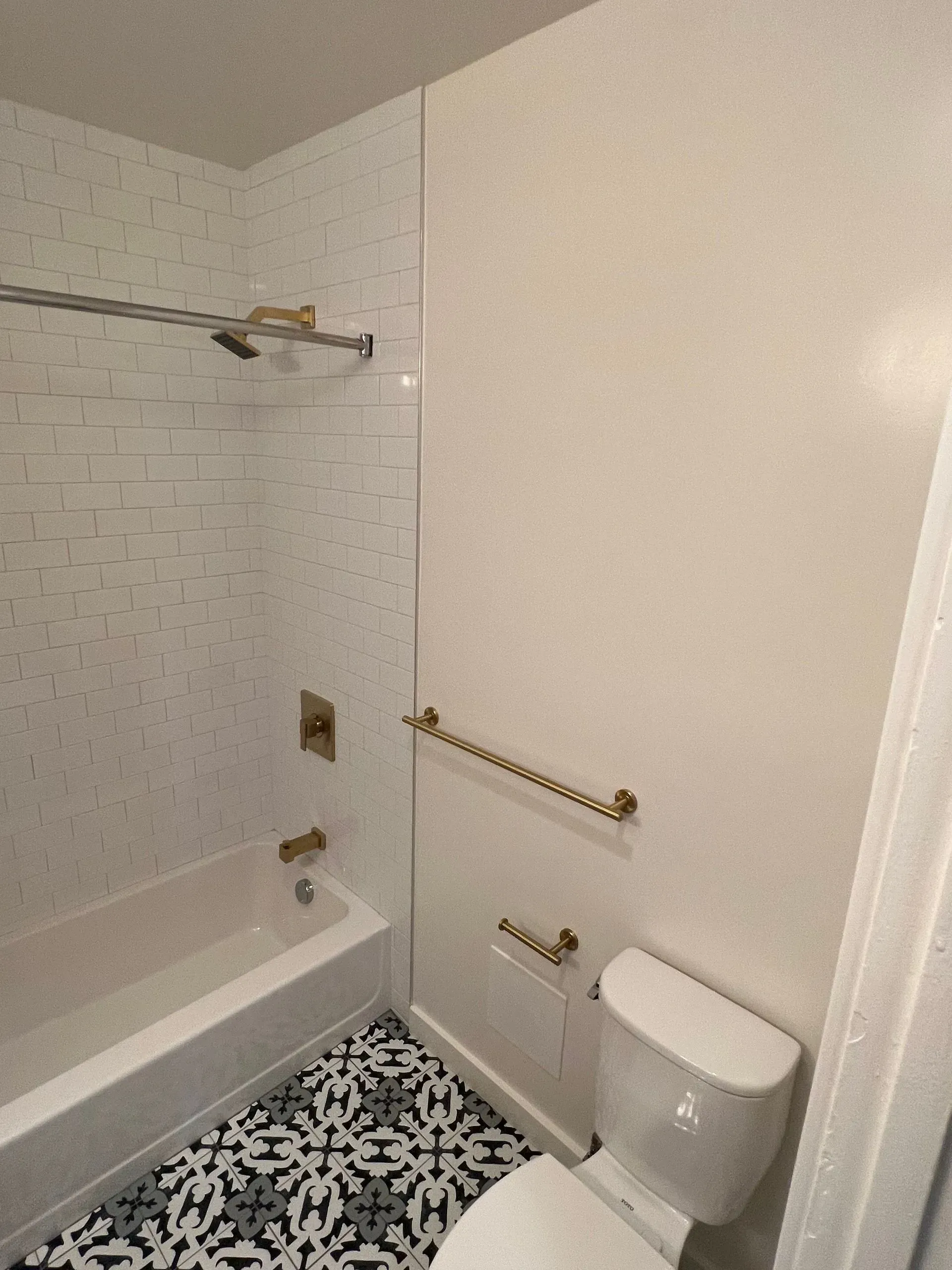 A bathroom with a toilet , bathtub and shower.