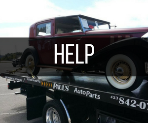 Classic maroon car on a tow truck, with 