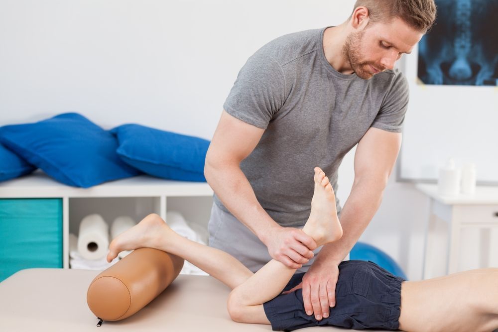 A Physical Therapist Performs a Leg Stretch — Elevate Injury Management in Sandy Bay, TAS