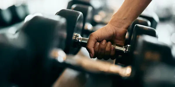 A Person’s Hand Grips a Metal Dumbbell — Elevate Injury Management in Sandy Bay, TAS