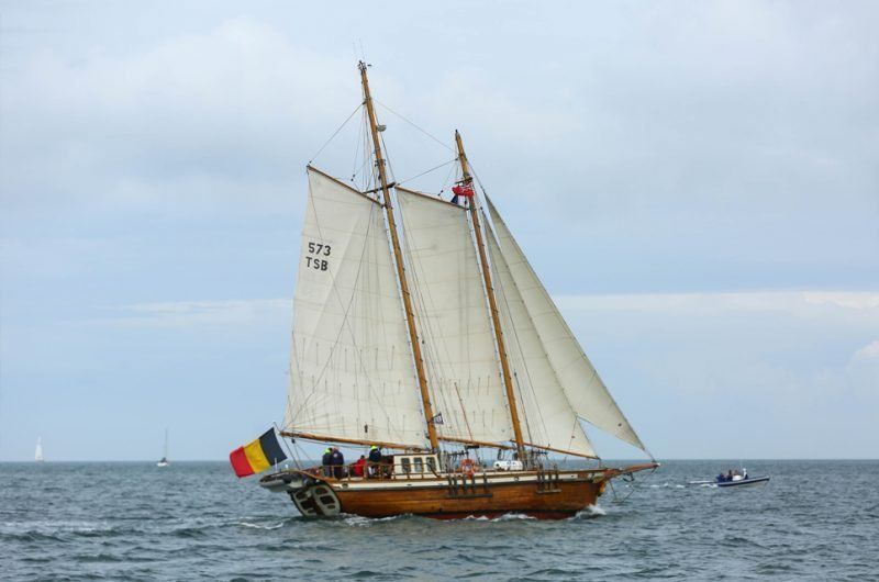 A large sailboat is floating on top of a body of water.