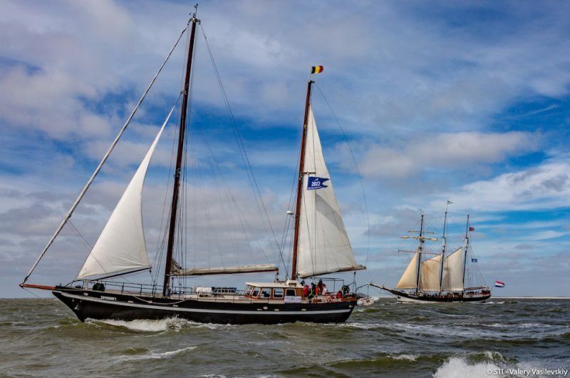 A group of sailboats are floating on top of a body of water.