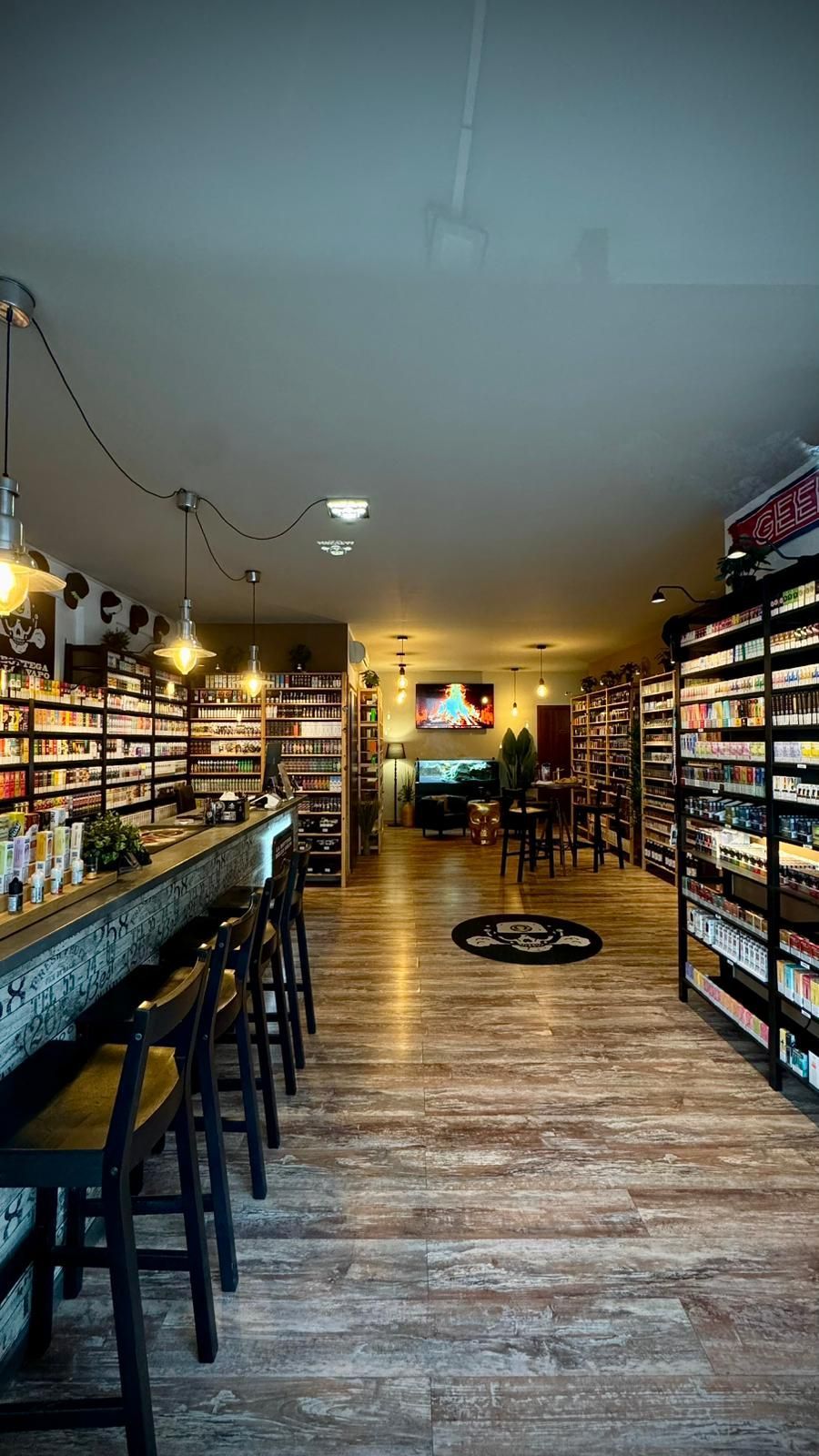 Interno di una cigar lounge con bar, scaffali pieni di sigari e posti a sedere.
