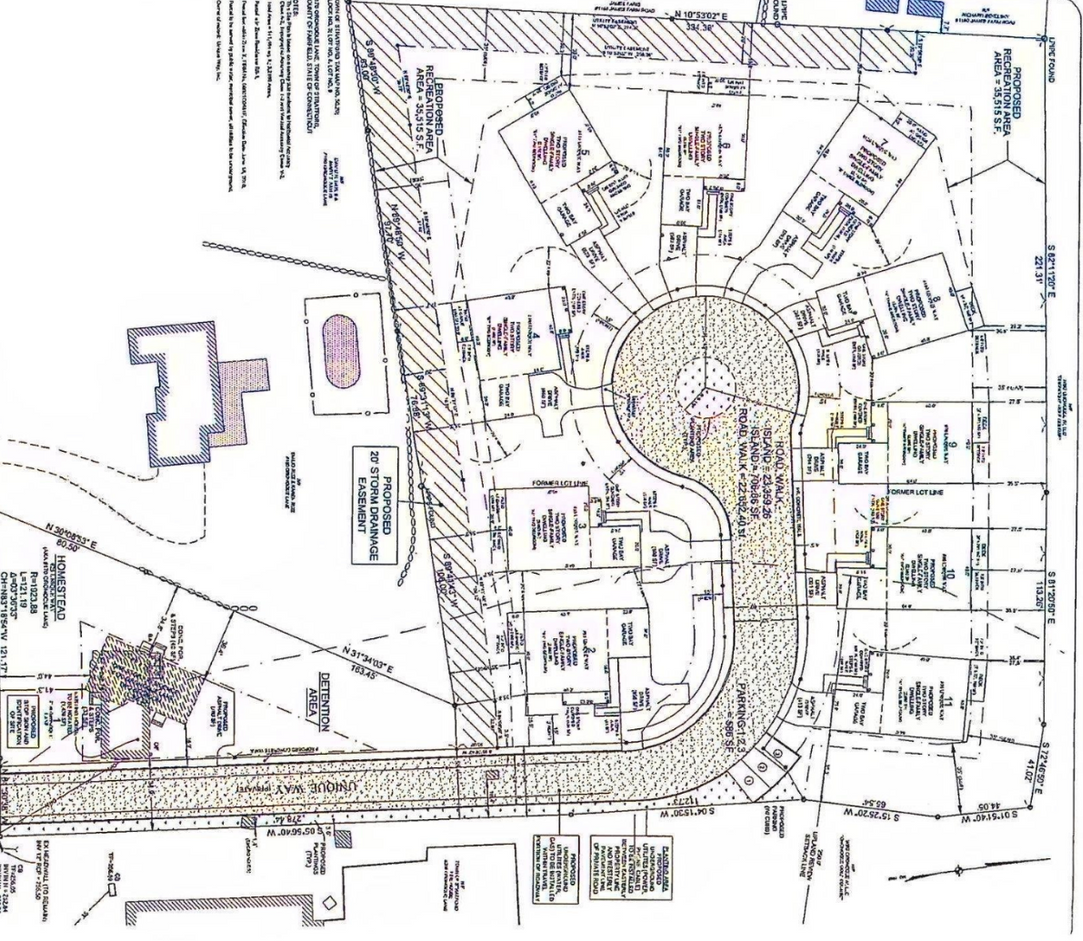 Architectural plan of a development with buildings, roads, and a central circular area.
