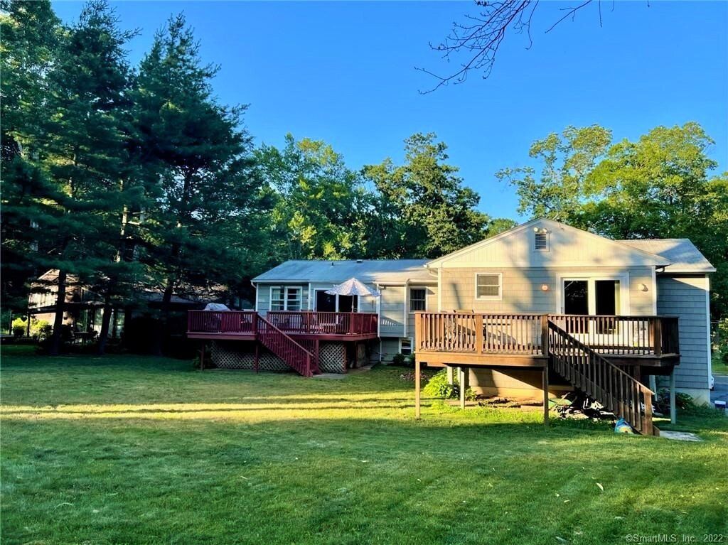 Two connected houses with wooden decks and a grassy yard.