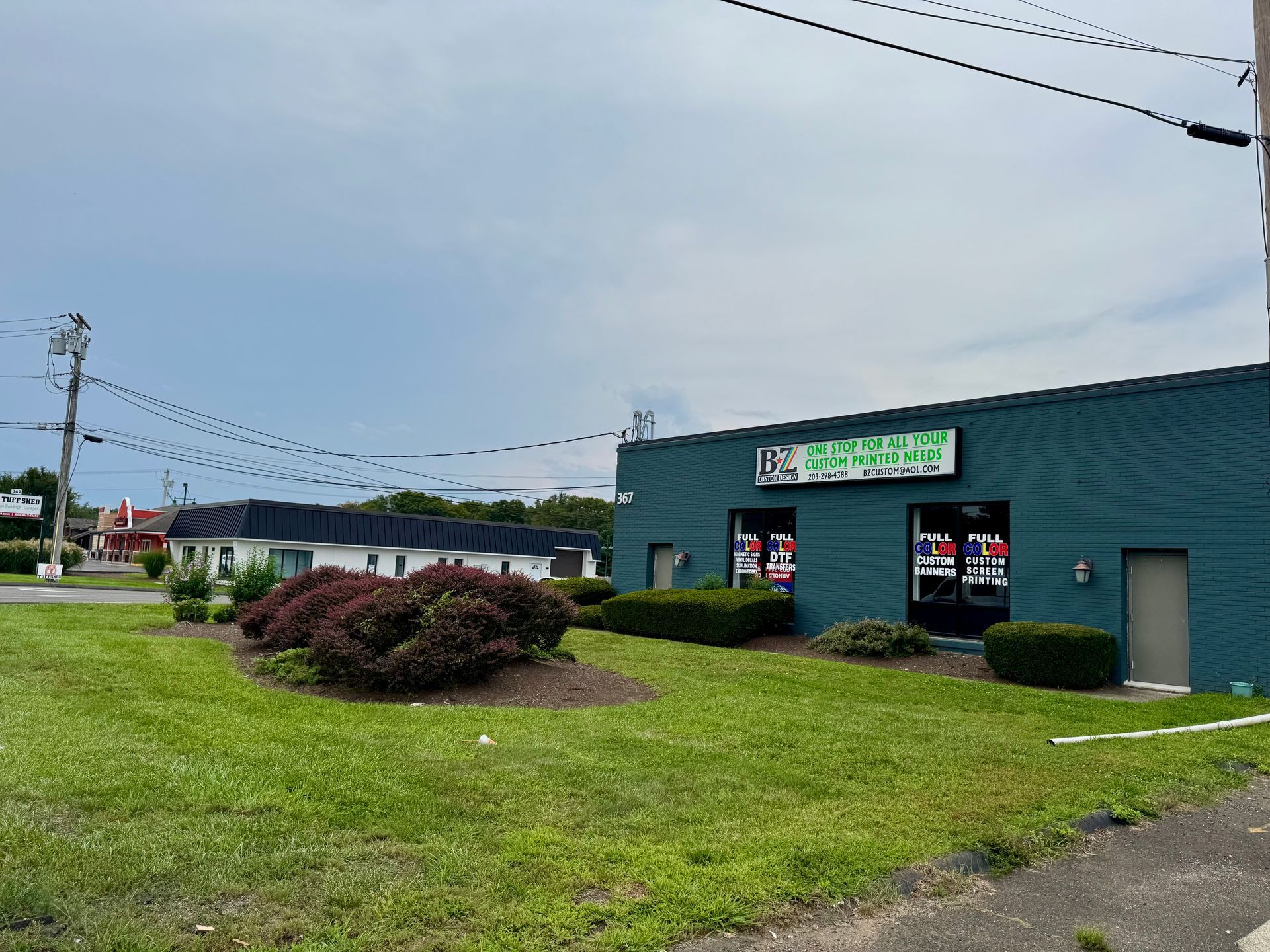 Shopping center exterior with cars in the parking lot. Stores include Ocean State Job Lot and Goodwill on a sunny day.