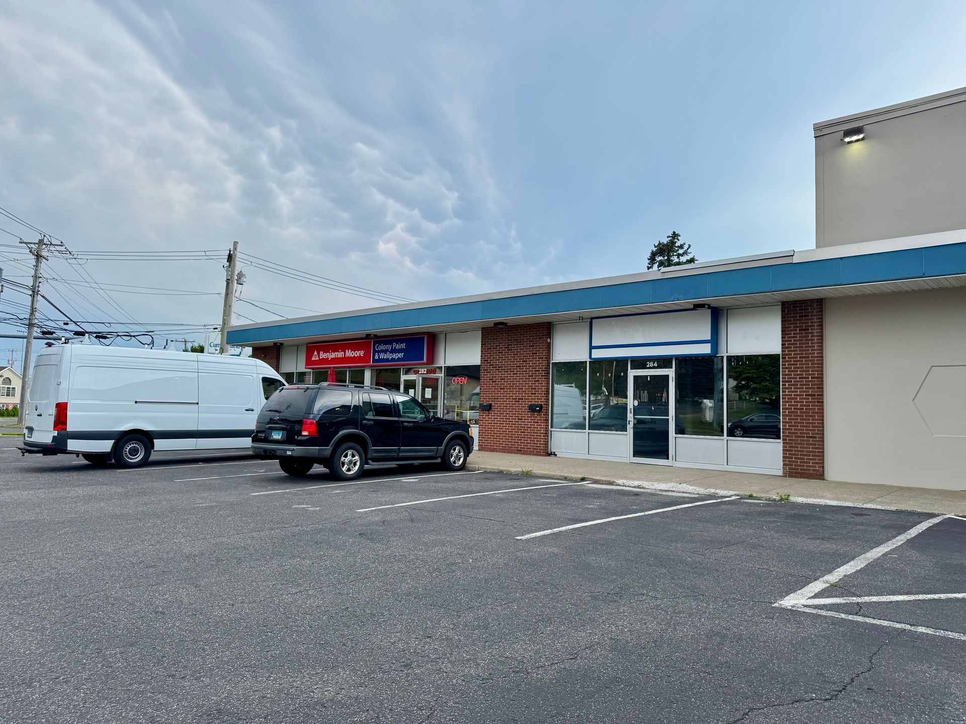 Shopping center exterior with cars in the parking lot. Stores include Ocean State Job Lot and Goodwill on a sunny day.