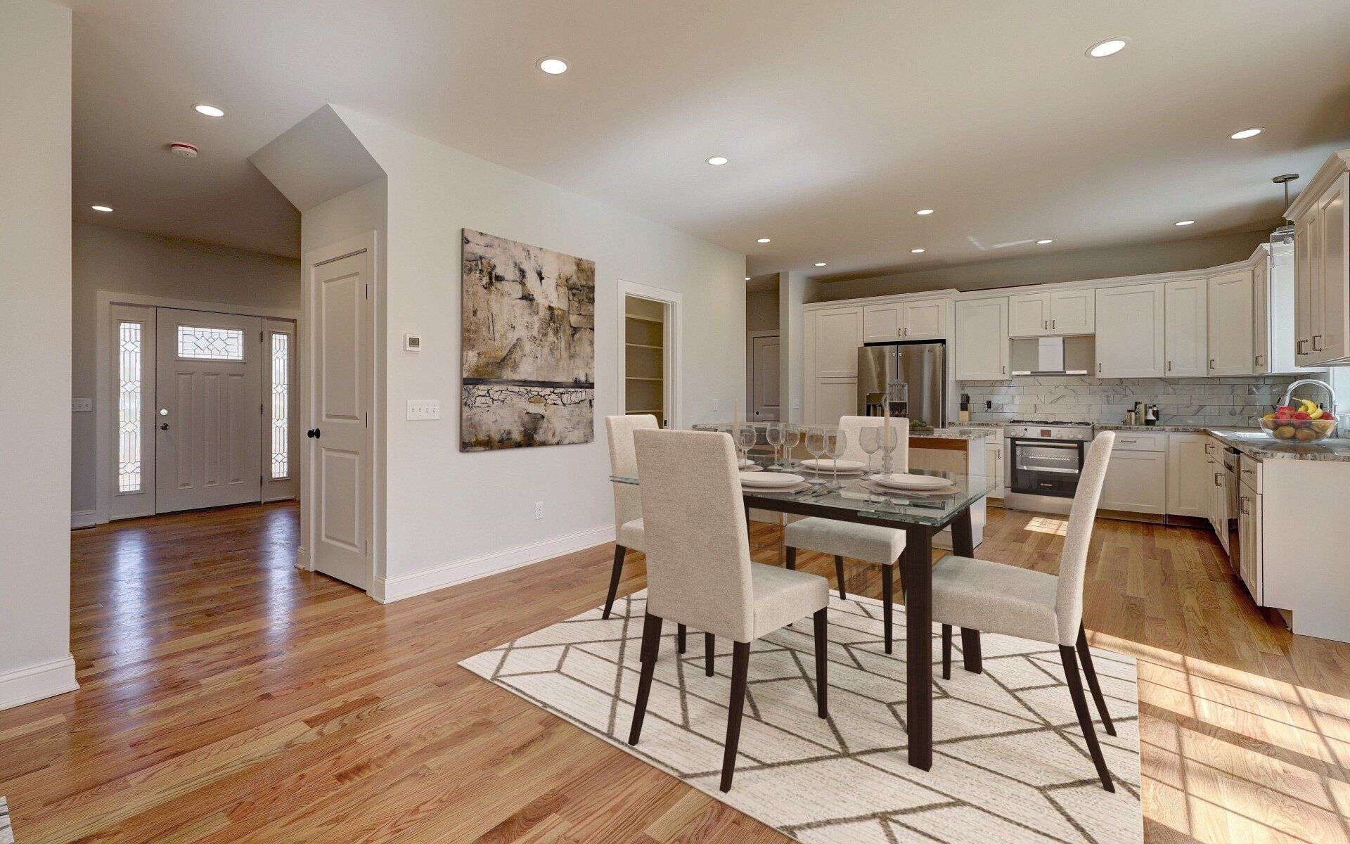 Dining room with table, chairs, kitchen, and entry door; hardwood floors, neutral colors.