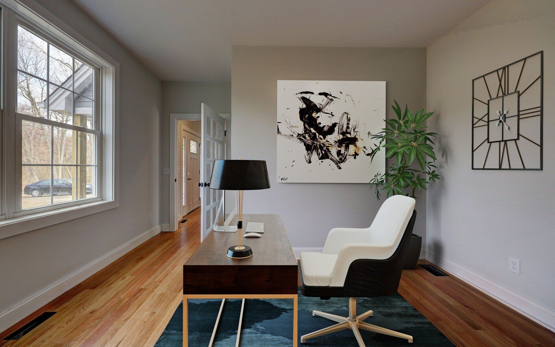 Office with desk, chair, abstract art, and large window. Hardwood floor.
