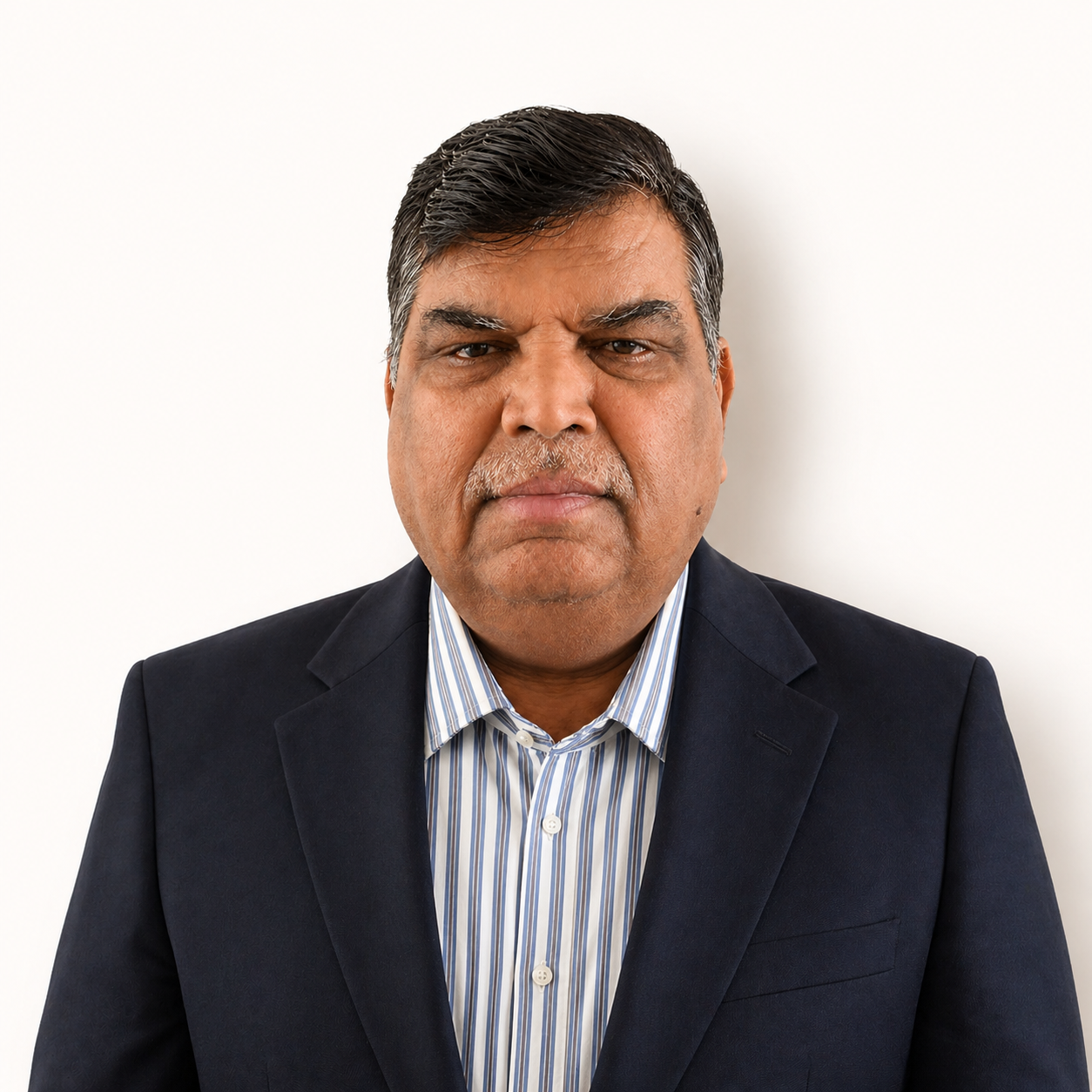 Portrait of a man in a dark blazer and striped shirt against a white background