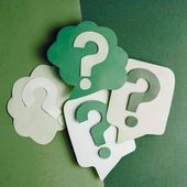 Green and white speech bubbles with question marks on a green background