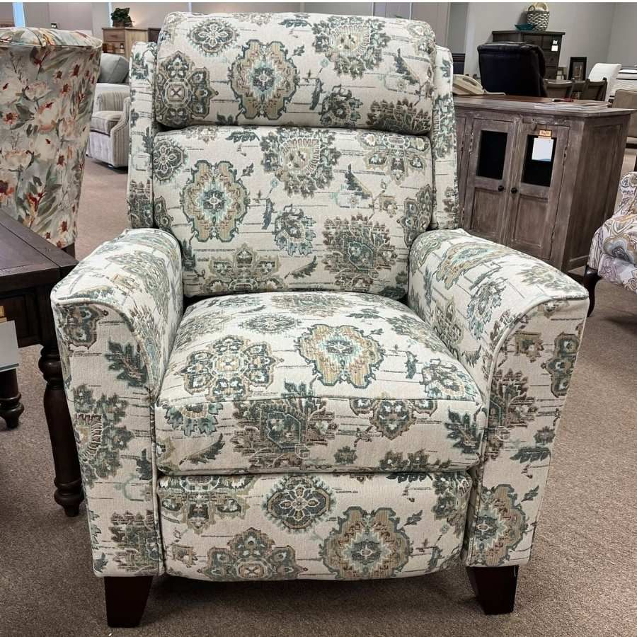 Patterned upholstered armchair in a furniture store showroom, with a cream and teal floral print.