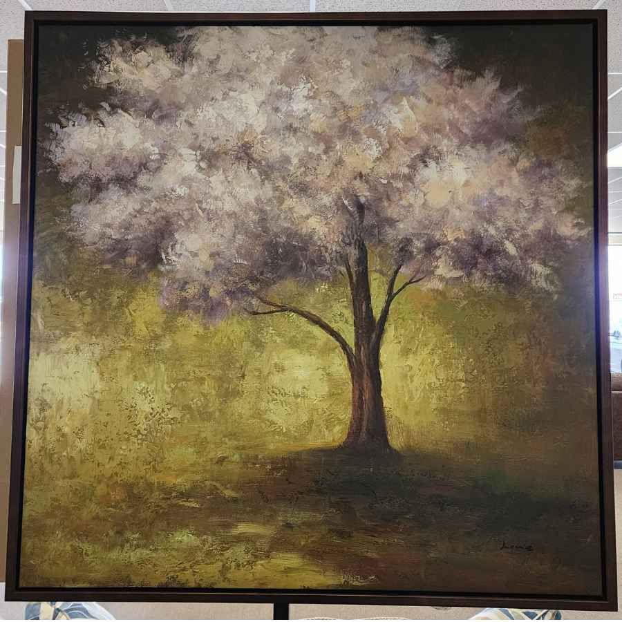 Painting of a lone tree with pale blossoms in a grassy field, framed in black.