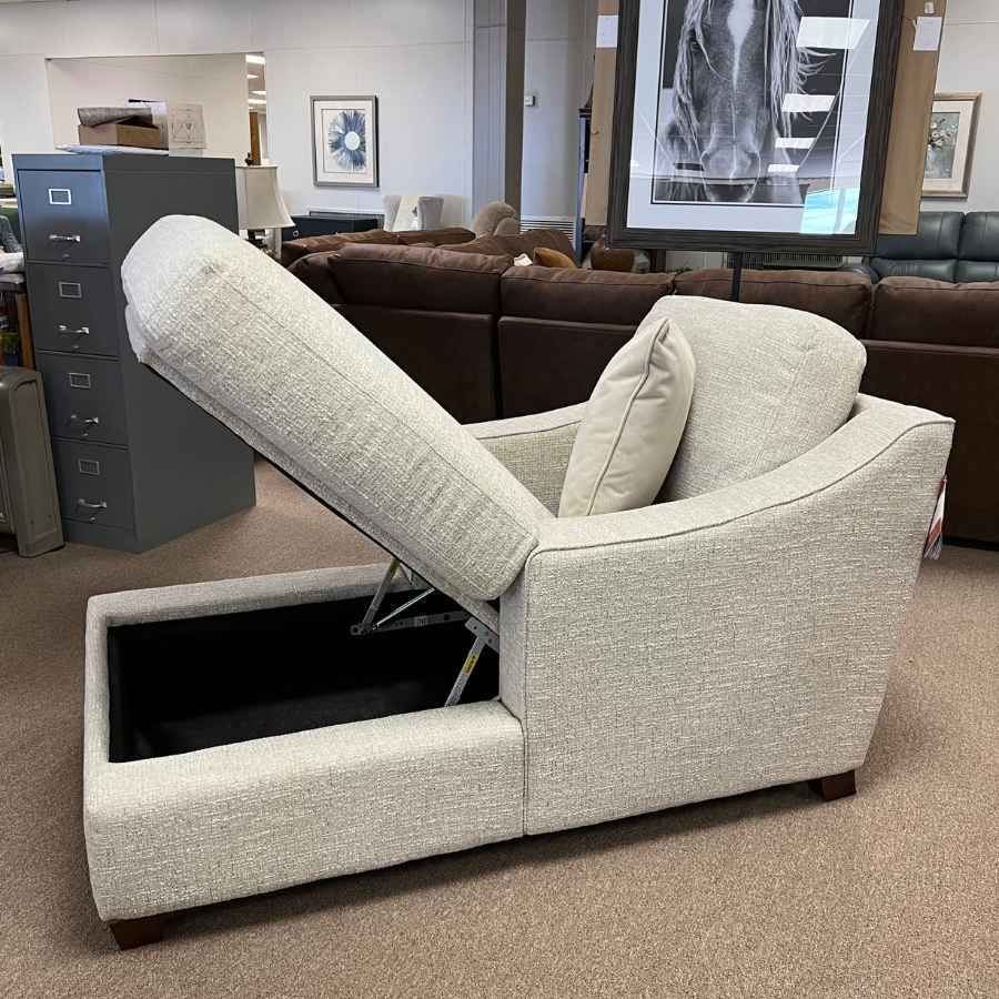 Beige lift chair reclined in a furniture store showroom, beside a brown couch.