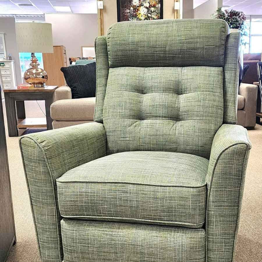 Green upholstered recliner chair in a furniture store showroom.