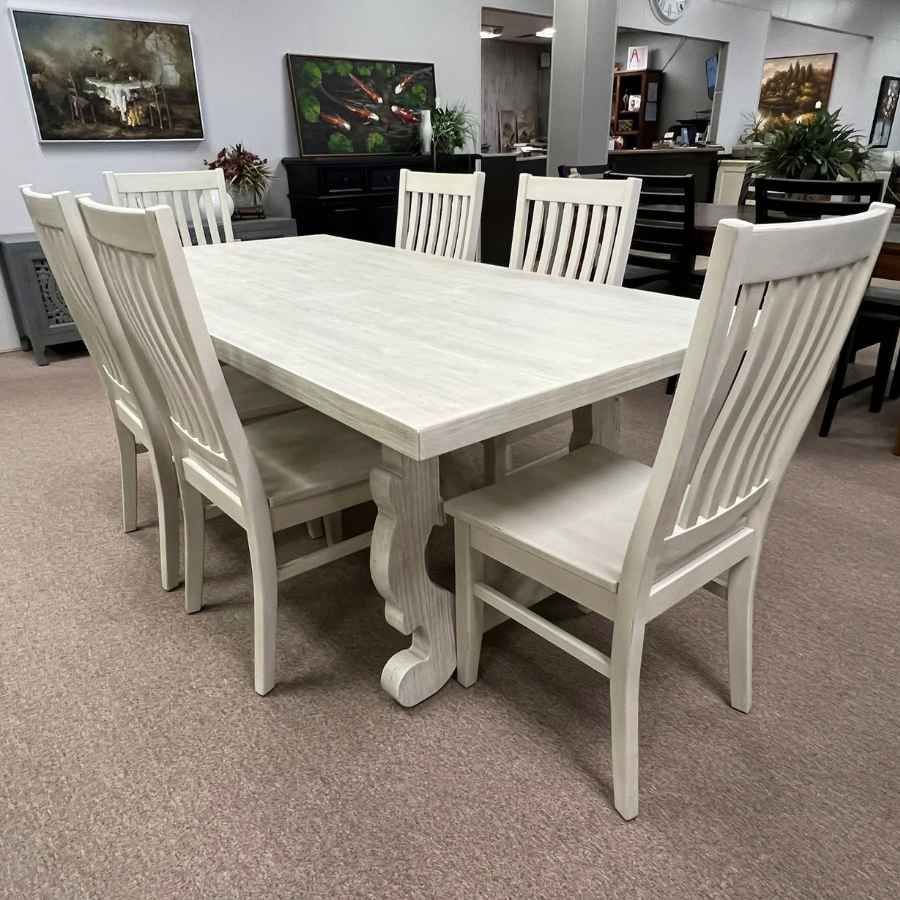 White wooden dining table with six matching chairs in a furniture showroom