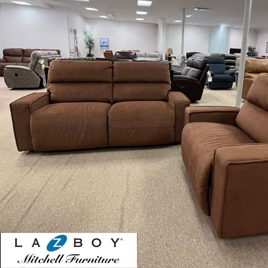 Furniture showroom with brown modular recliners on beige carpet, La-Z-Boy logo in lower left.