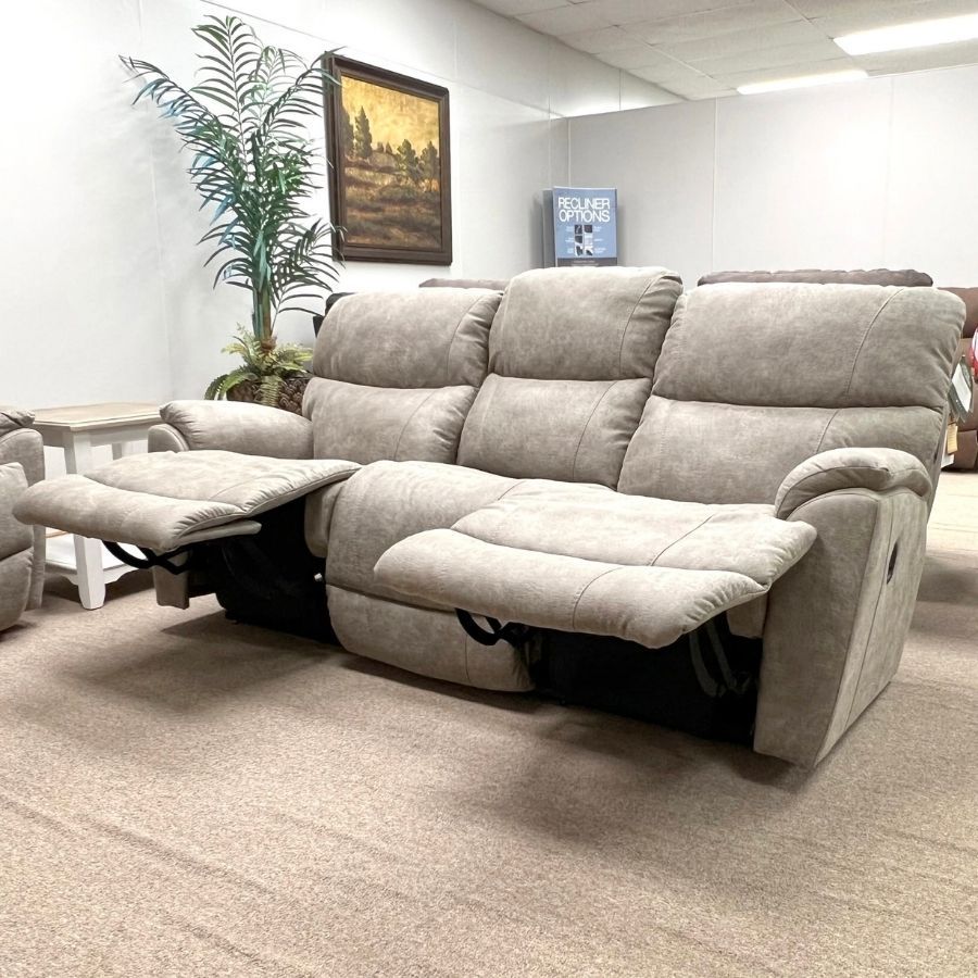 Light gray reclining sofa with pull-out footrests in a showroom-style living room.