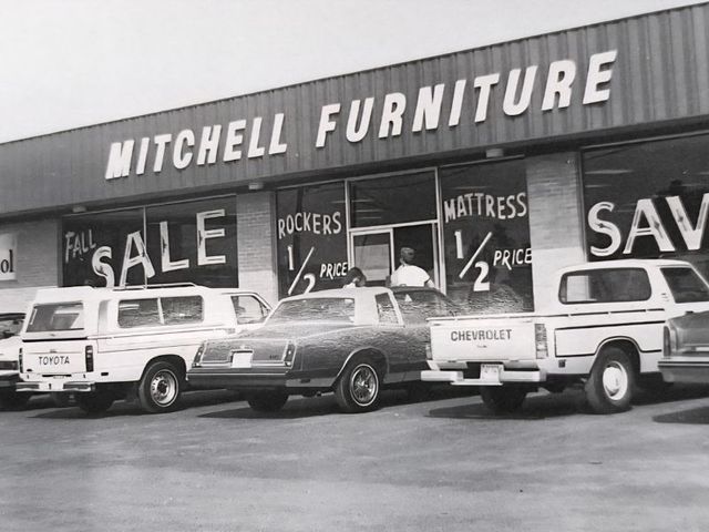 Mitchell Furniture storefront with glass entrance and blue-striped accessible parking space in front