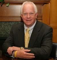 A man in a suit and tie is sitting at a table.