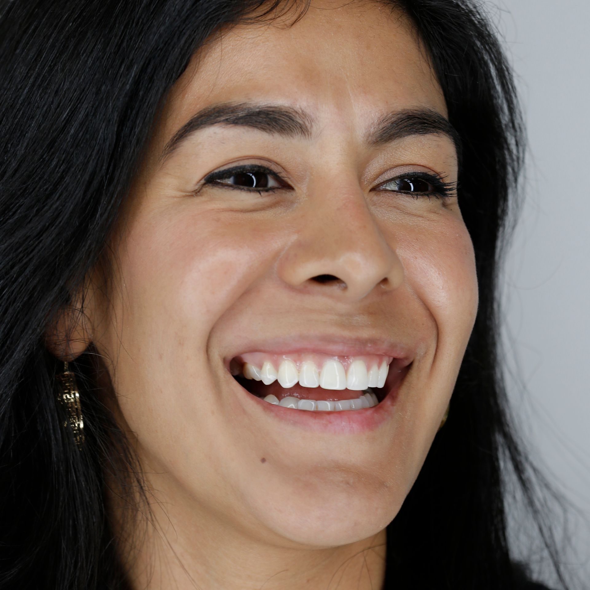 A close up of a woman 's face with a smile on her face