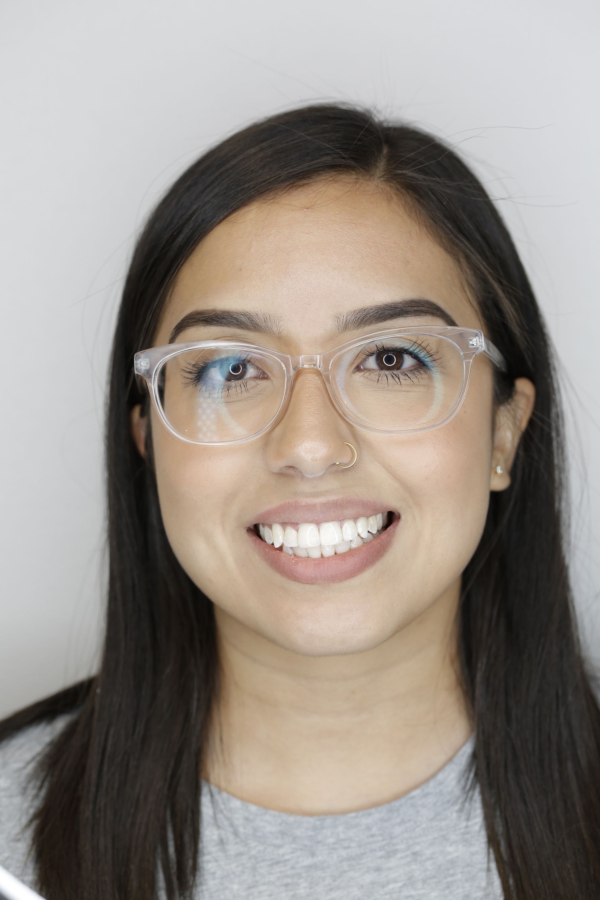 A close up of a woman wearing glasses and smiling.