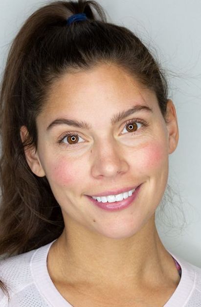A woman with a ponytail is smiling for the camera.