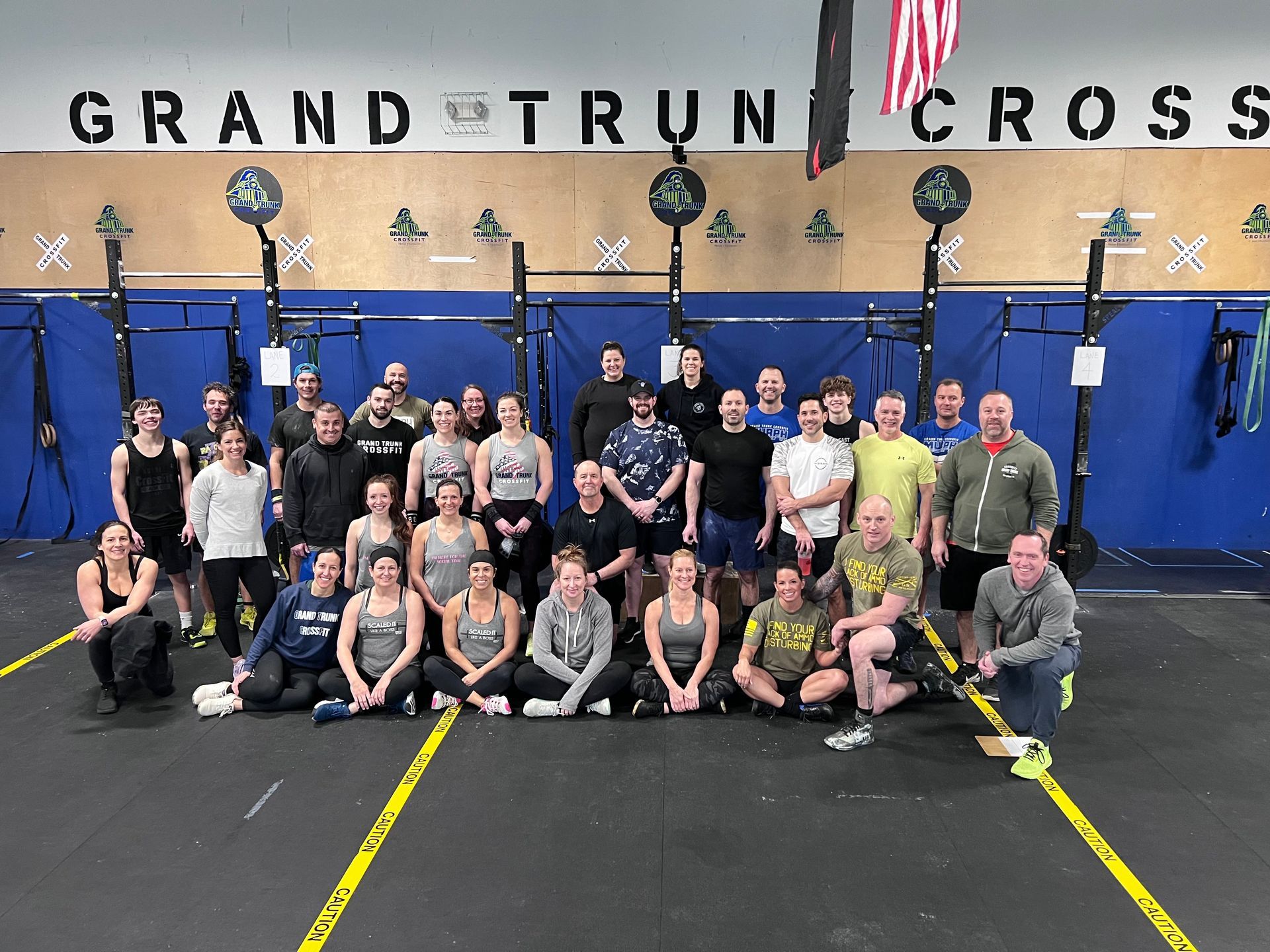 A group of people are posing for a picture in front of a sign that says grand trun cross