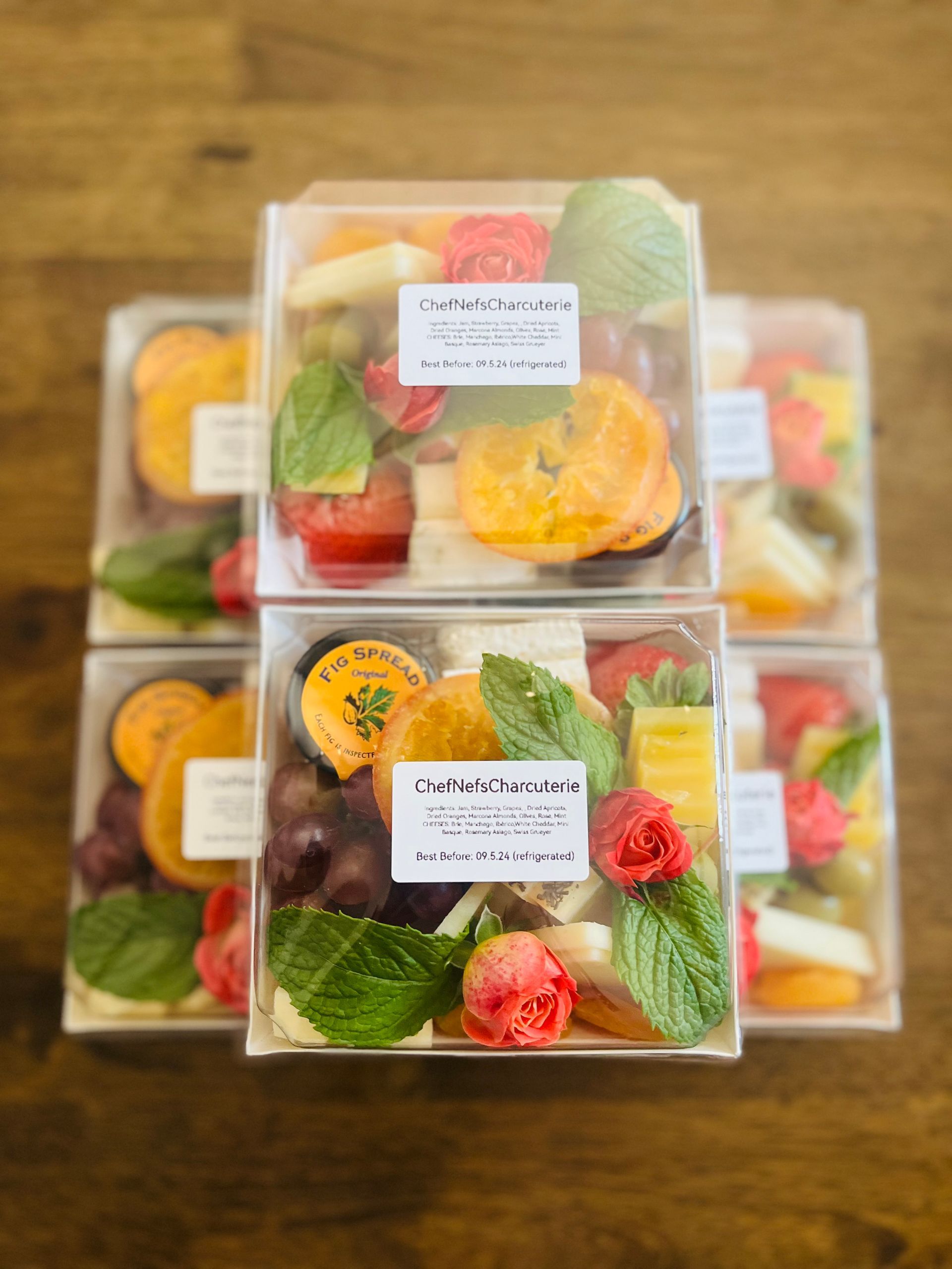A stack of boxes filled with fruit and vegetables on a wooden table.