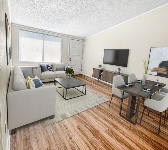Photo of a living room wiith the front door in the background, and a dining area in the foreground
