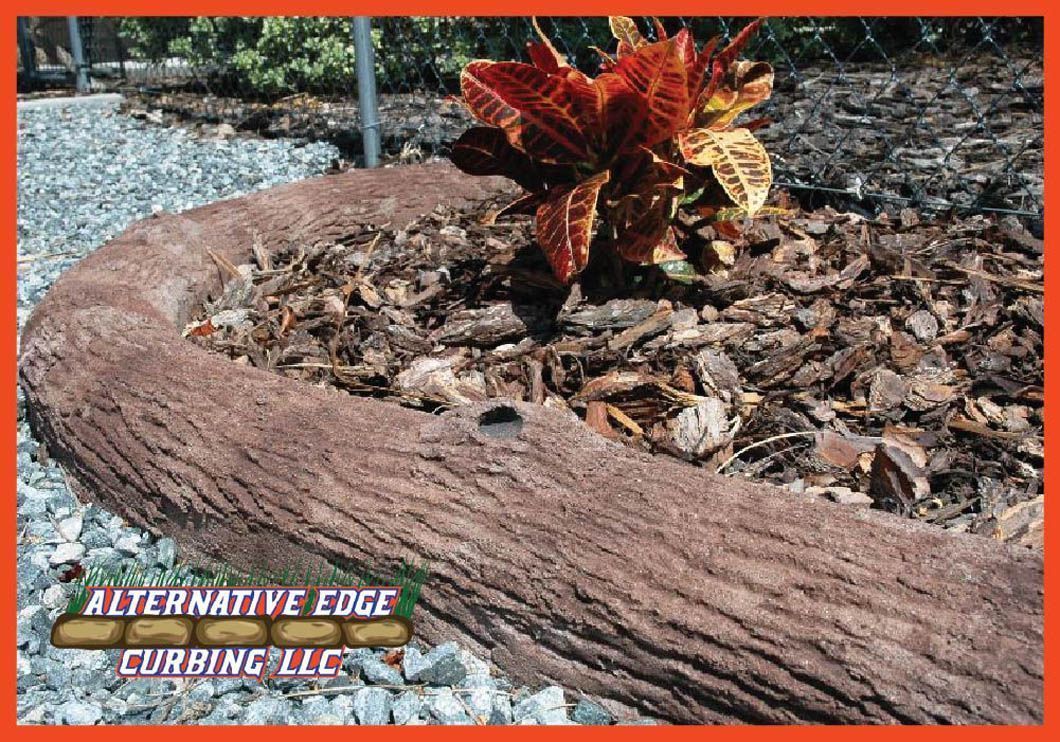 Brown decorative concrete curbing with a textured log appearance, surrounding a garden bed.