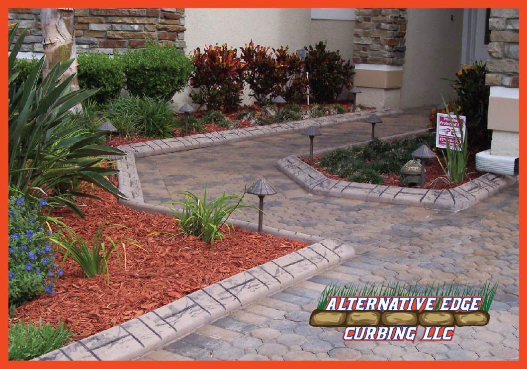 Brick-edged walkway with mulch landscaping, lit by path lights. Alternative Edge Curbing logo in foreground.