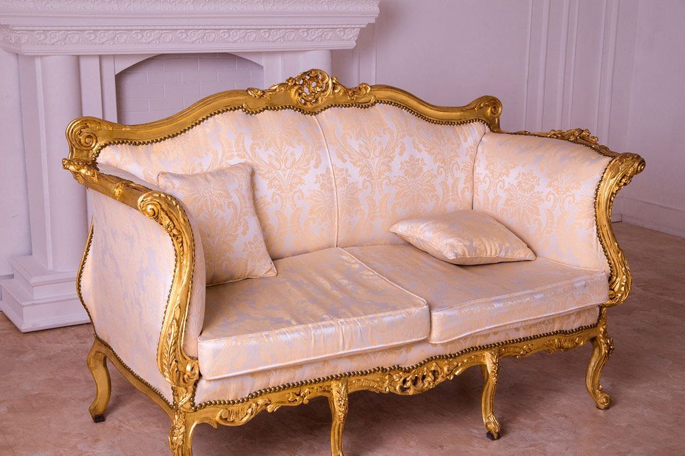 A White And Gold Couch Is Sitting In Front Of A Fireplace — Coastal Upholstery In Berkeley Vale, NSW