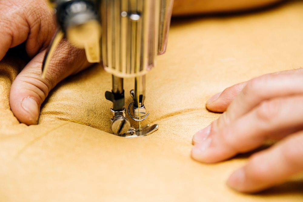 A Person Is Using A Sewing Machine To Sew A Piece Of Fabric — Coastal Upholstery In Berkeley Vale, NSW