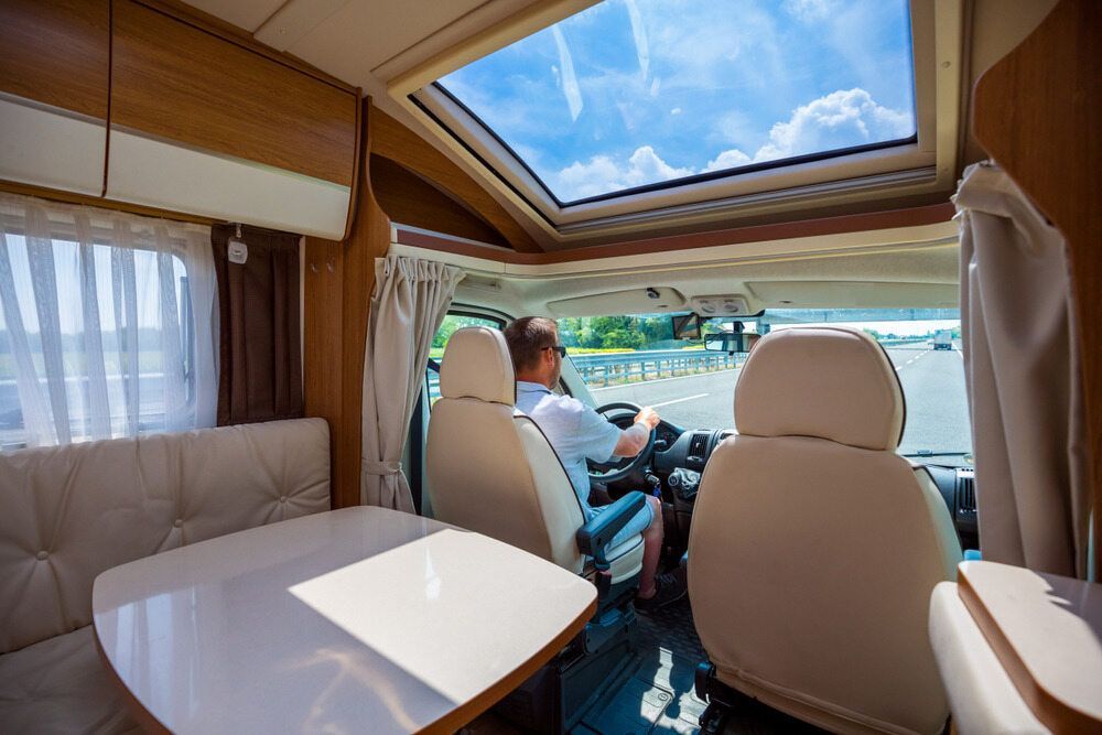 A Man Is Driving A Camper Van Down A Road — Coastal Upholstery In Berkeley Vale, NSW