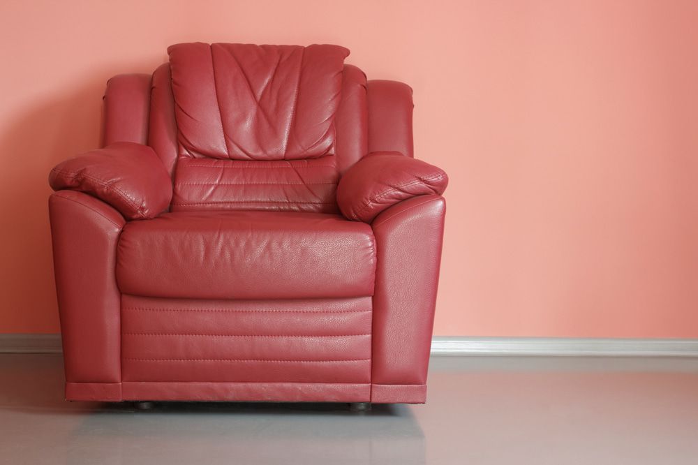 A Red Leather Chair Is Sitting In Front Of A Pink Wall — Coastal Upholstery In Berkeley Vale, NSW
