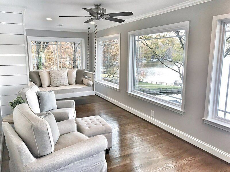 A Living Room With A Couch, Chair, Ottoman And Ceiling Fan — Coastal Upholstery In Berkeley Vale, NSW