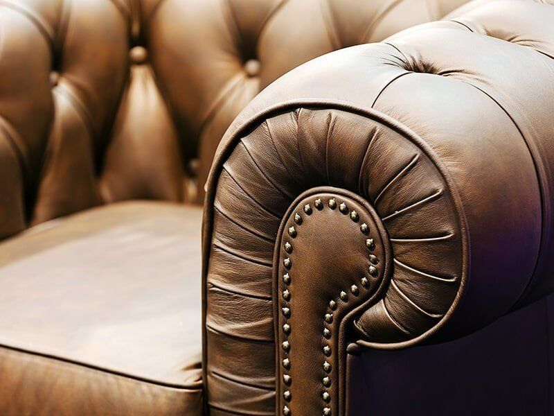 A Close Up Of The Arm Of A Brown Leather Couch — Coastal Upholstery In Berkeley Vale, NSW