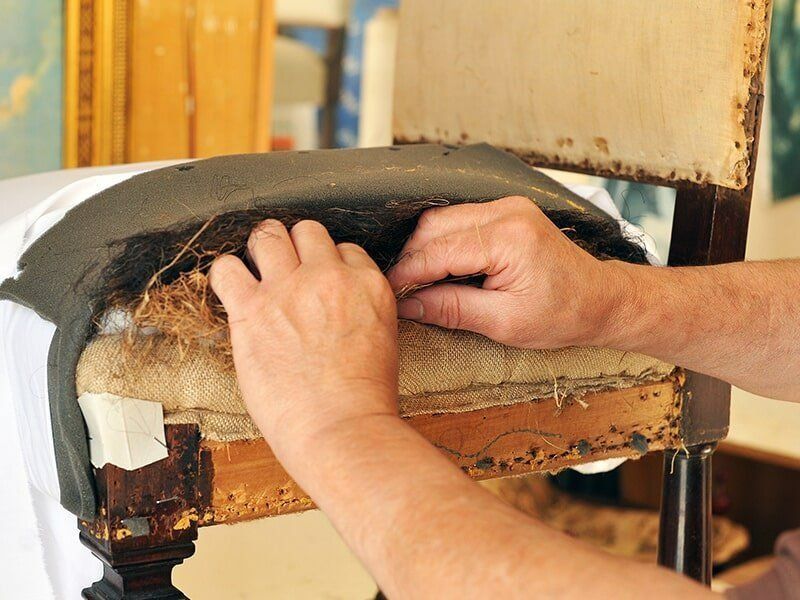 A Person Is Fixing A Chair With Their Hands — Coastal Upholstery In Berkeley Vale, NSW