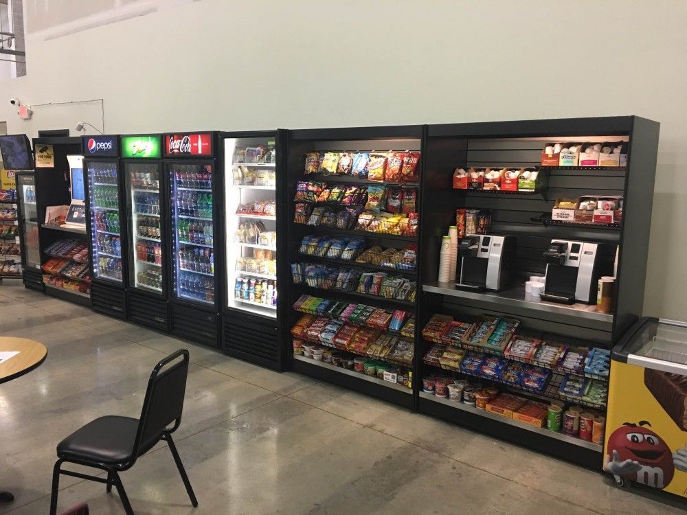A row of vending machines are lined up next to each other in a store.