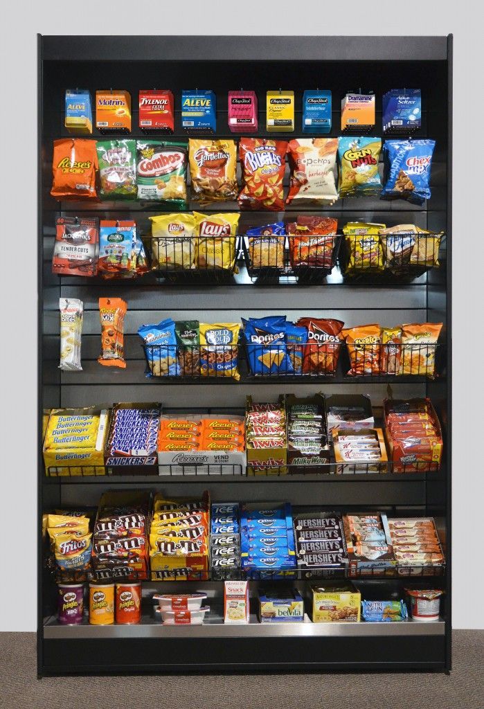 A micro market shelf filled with snacks and candy including m & m 's