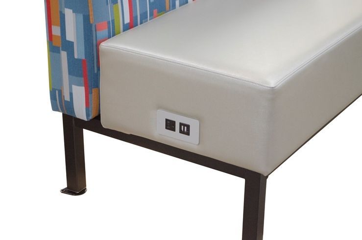 A bench with a power outlet on the side of it.