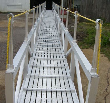 A long metal marine gangway with a yellow rope attached to it